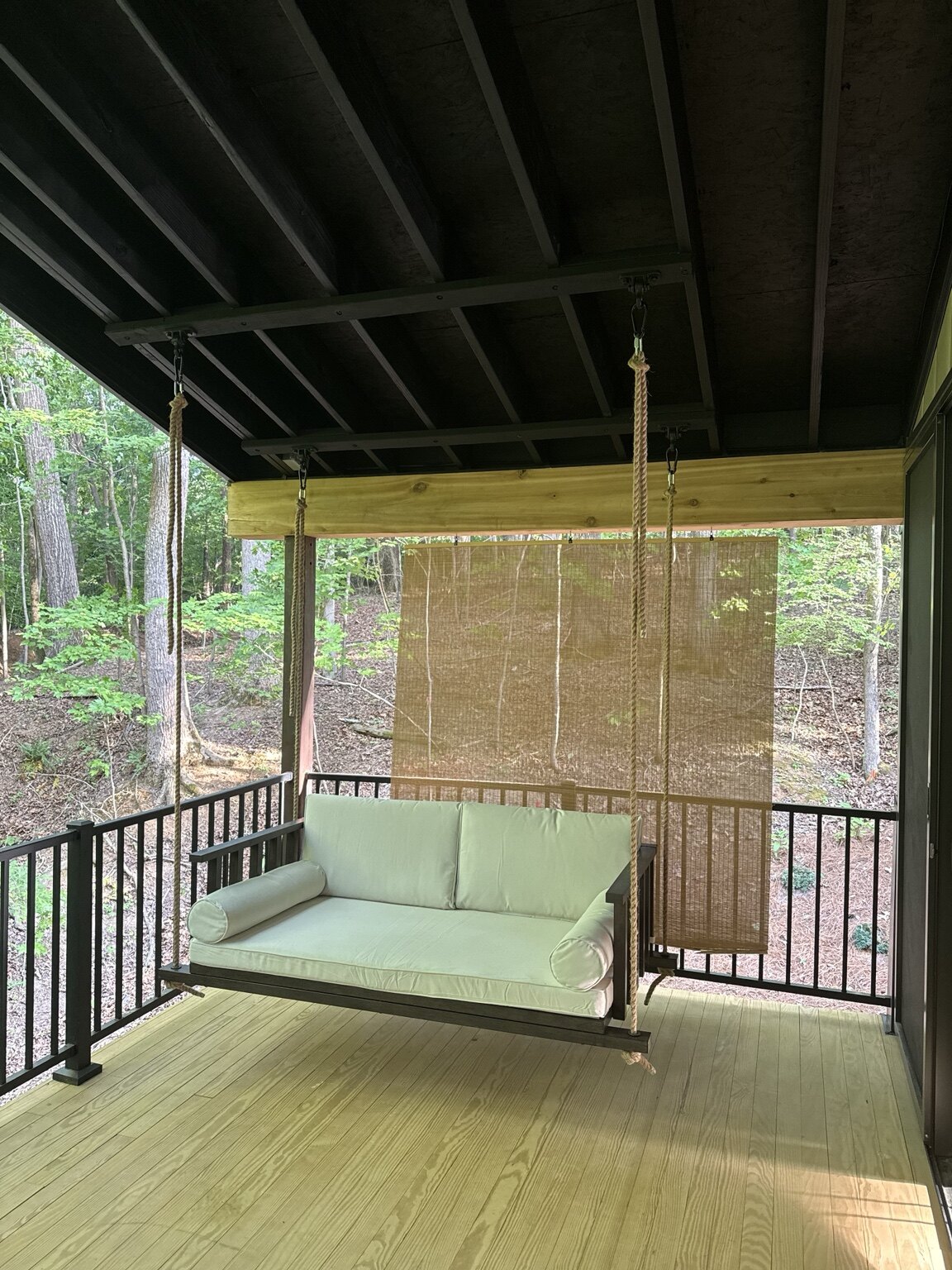 Hanging porch swing installed beneath a covered deck