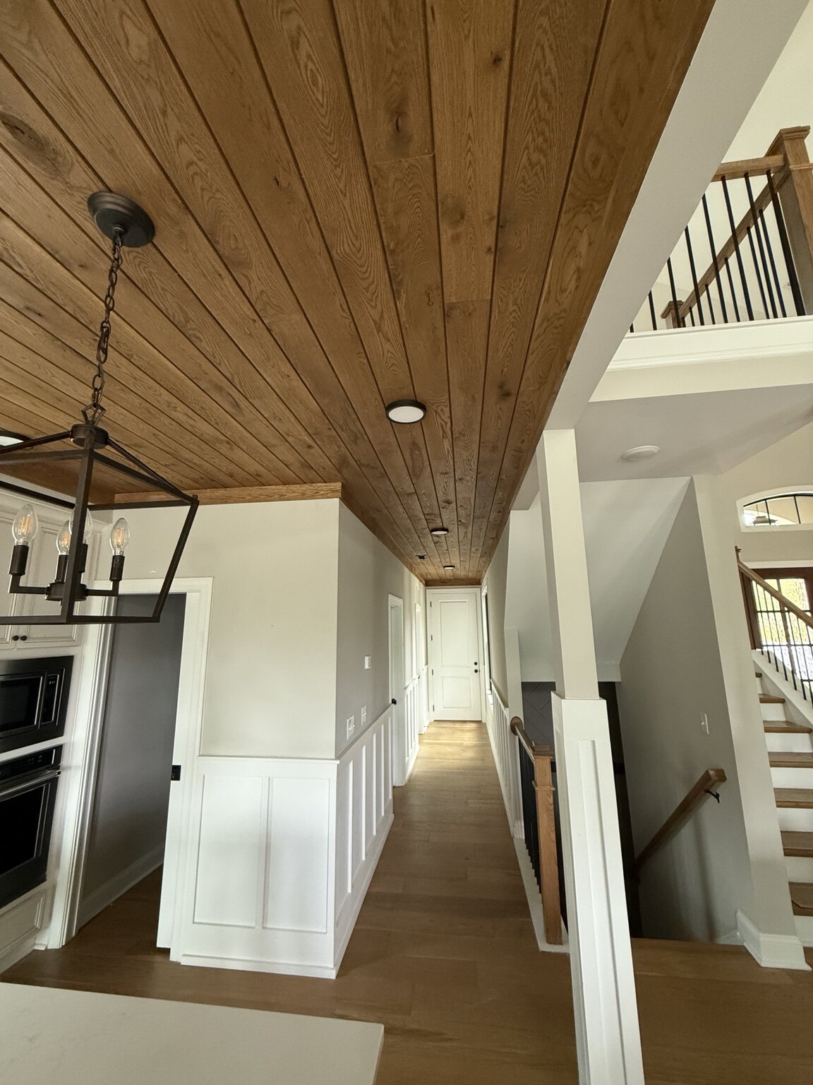 Tongue-and-groove ceiling continuing through an open hallway