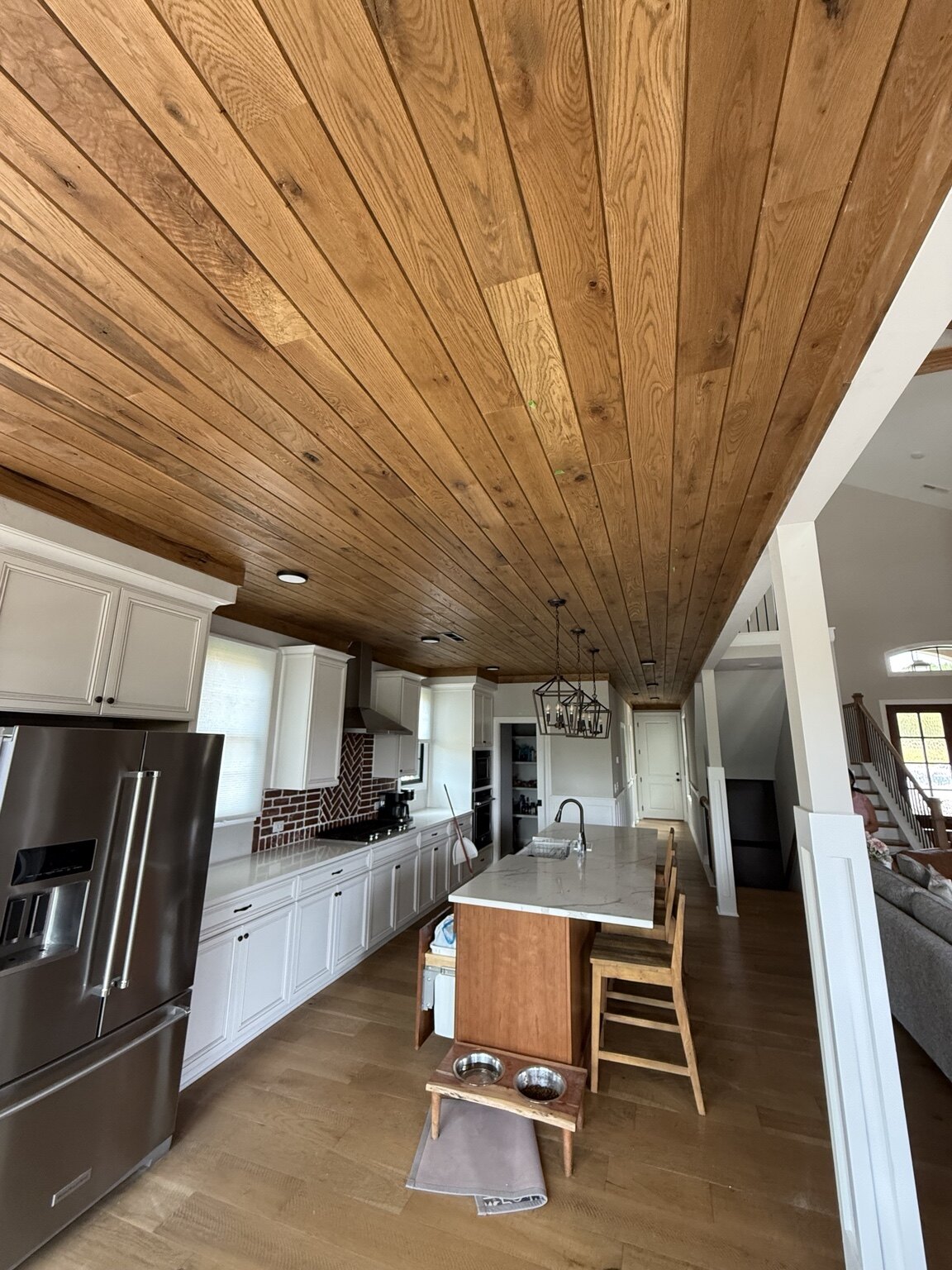 Finished oak tongue-and-groove ceiling extending through a kitchen